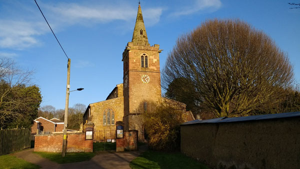St Faith's church, Kilsby, from the west, showing the bell tower and early 19th century churchyard gates
